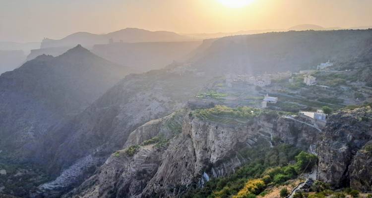 Een panoramisch uitzicht op een bergachtig landschap bij schemering.