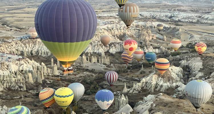 Hot air balloons flying over the unique rock formations in Cappadocia.