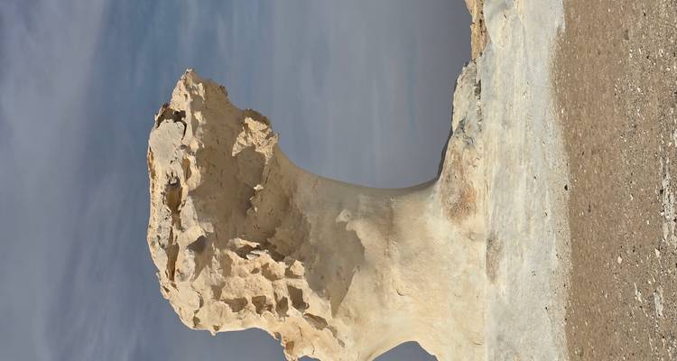 Witte rotsformatie tegen een bewolkte hemel.