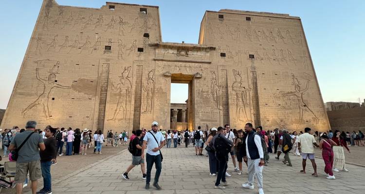 Toeristen bij de ingang van de Edfu-tempel met hiërogliefen.