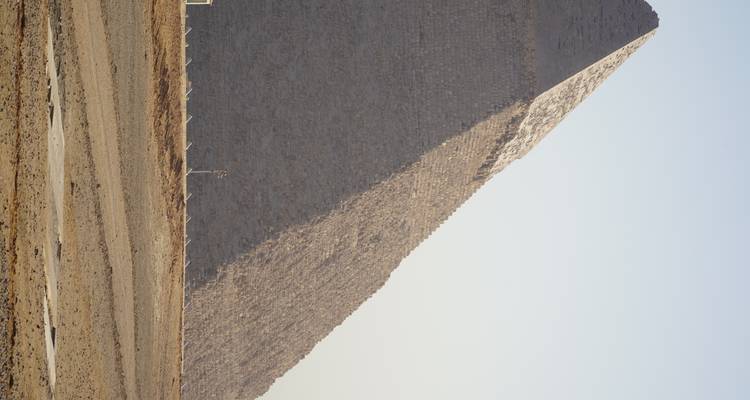 Gedeeltelijk zicht op een Piramide in een woestijn.