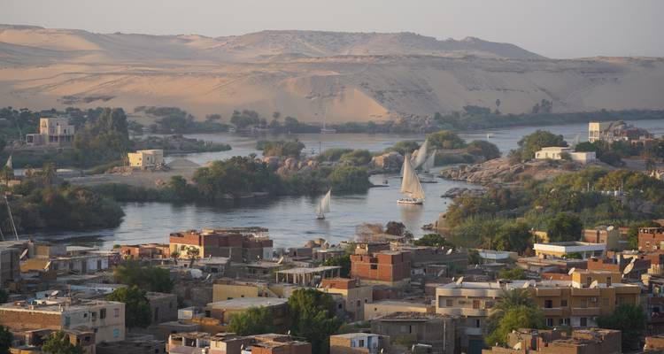 Luchtfoto van een rivier met boten en een stad.
