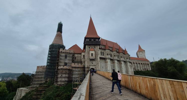 Château de Corvin avec des touristes sur l'approche du pont.