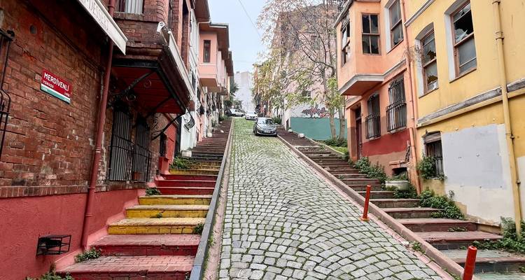 Colorful stairs on a steep cobblestone street.