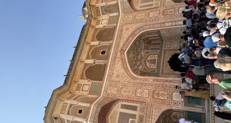 Versierde ingang van een historisch gebouw met een menigte.