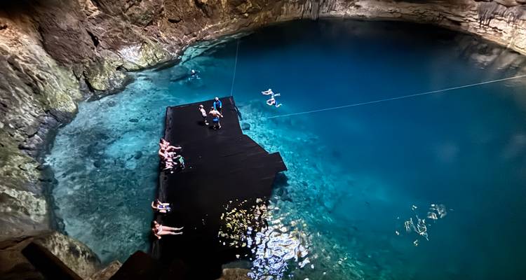 Ein wunderschöner Cenote mit kristallklarem Wasser und einer Holzplattform.