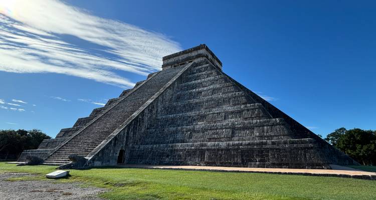 Eine große antike Steinpyramide unter einem klaren blauen Himmel.