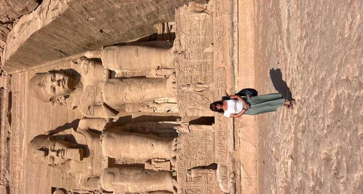 Touriste debout devant les statues massives d'Abou Simbel.