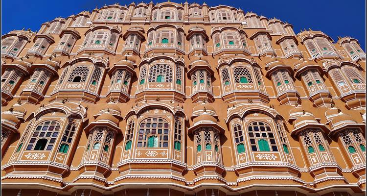 Hawa Mahal mit seiner detaillierten Architektur vor einem blauen Himmel.