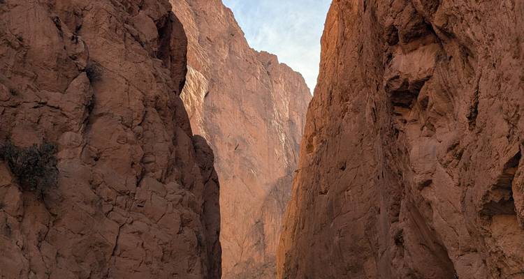 Kloof met hoge rotsachtige kliffen onder een blauwe hemel.