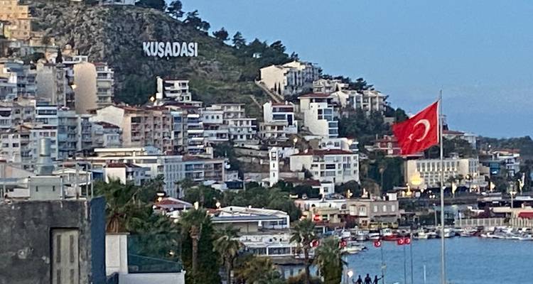 Stad op heuvelflank met gebouwen en Turkse vlag.