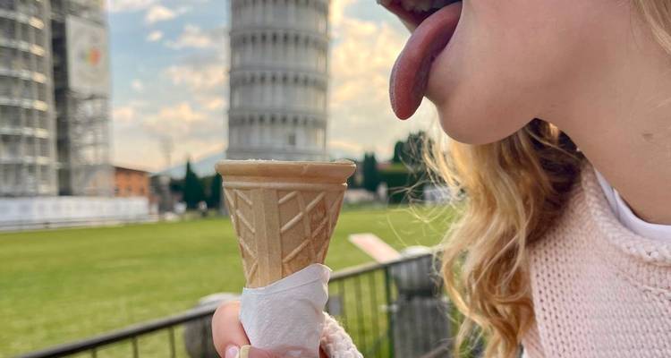 Person, die humorvoll vorgibt, den Schiefen Turm von Pisa zu lecken.