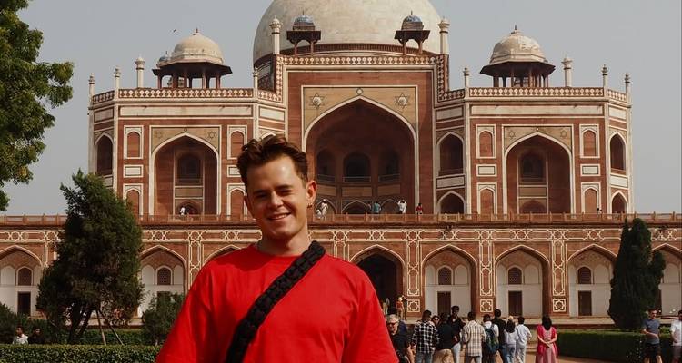 Persoon poseert voor het graf van Humayun.