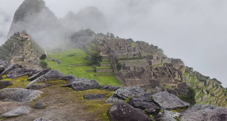 Vista panorámica de Machu Picchu parcialmente cubierta por la niebla.