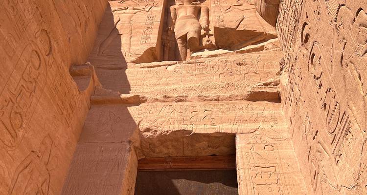 Intrincados tallados y una estatua imponente en un sitio arqueológico egipcio.