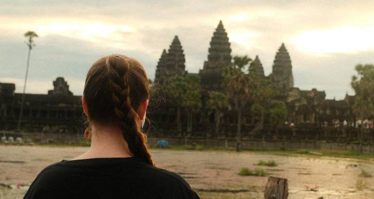 Achteraanzicht van een vrouw die naar Angkor Wat kijkt.