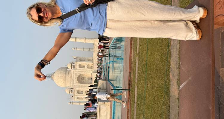 Mujer posando como si estuviera sosteniendo la parte superior del Taj Mahal.