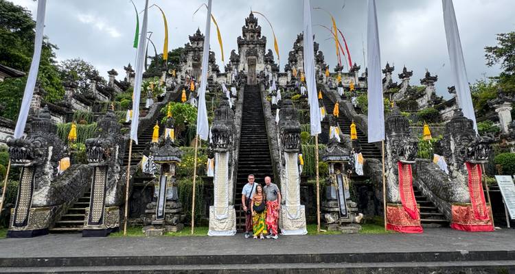 Twee mensen die staan bij de trappen van een grote Balinese tempel.