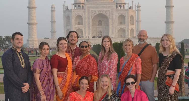 Groep mensen in traditionele kledij voor de Taj Mahal.