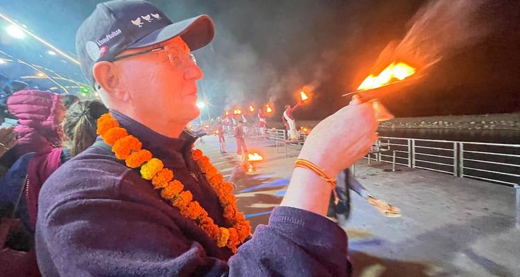 Person participating in a traditional river ceremony at night.