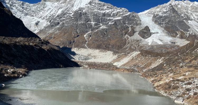 Lac gelé entouré de montagnes enneigées.