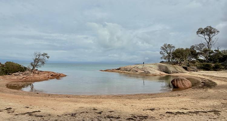 Una bahía serena con aguas tranquilas y costas rocosas.