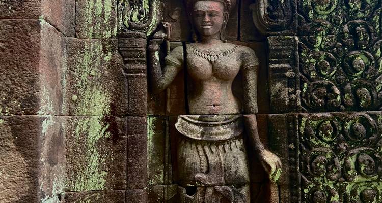 Steenbeeldhouwwerk van een vrouwenfiguur op een muur.