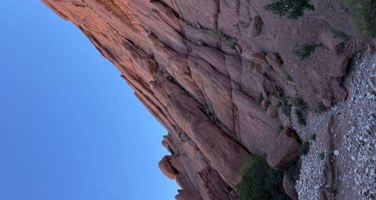 Uitzicht op een rotsachtige klif met een heldere blauwe lucht.