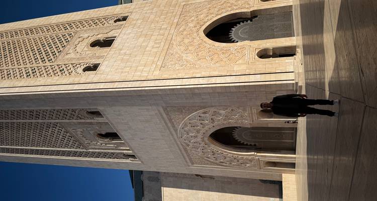 Een persoon die voor een grote historische toren staat.