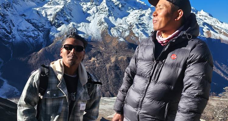 Dos hombres disfrutando de una vista de montañas cubiertas de nieve.