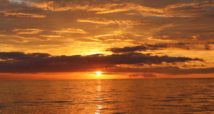 Een levendige oranje zonsondergang boven de oceaan.