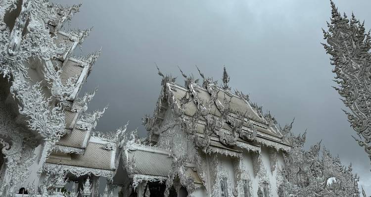 Ingewikkeld ontworpen witte tempel met bewolkte hemel.