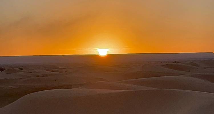Zonsondergang boven zandduinen in de woestijn.