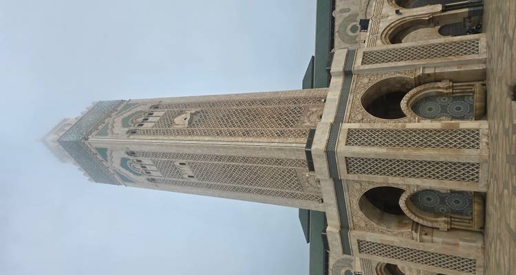 Ein großartiger Moscheeturm mit kunstvollen Fliesenarbeiten unter klarem Himmel.