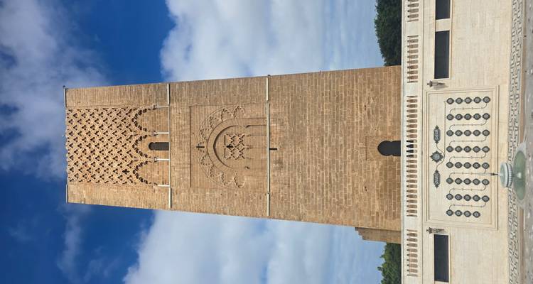 Ein hoher, brauner historischer Turm vor einem blauen Himmel.