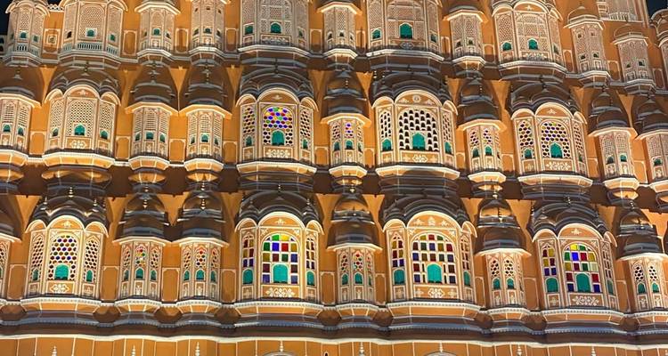 A beautifully lit building with intricate architecture and colorful windows.