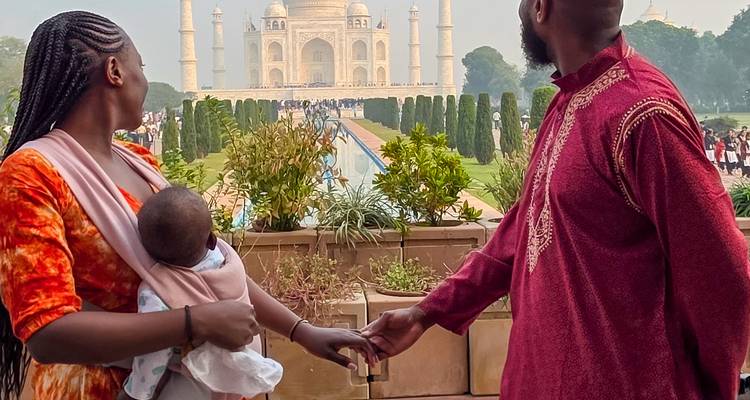 Pareja tomada de la mano frente al Taj Mahal