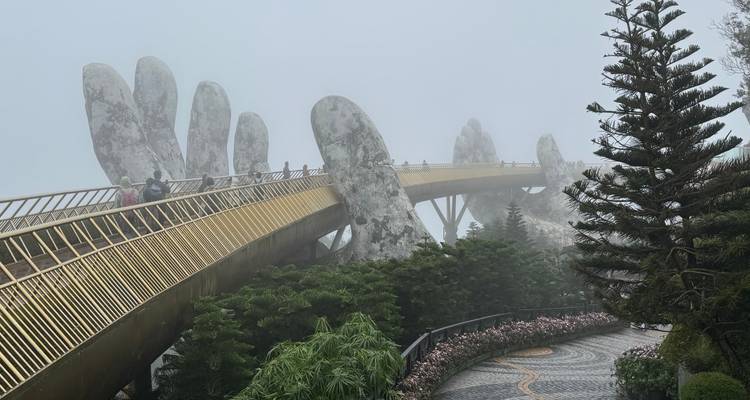 Vista brumosa del Puente Dorado sostenido by manos gigantes en un jardín.