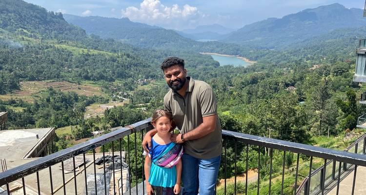 Man en kind poseren met berg- en meerzicht.