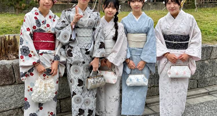 Cinq personnes portant des kimonos traditionnels posant pour une photo.