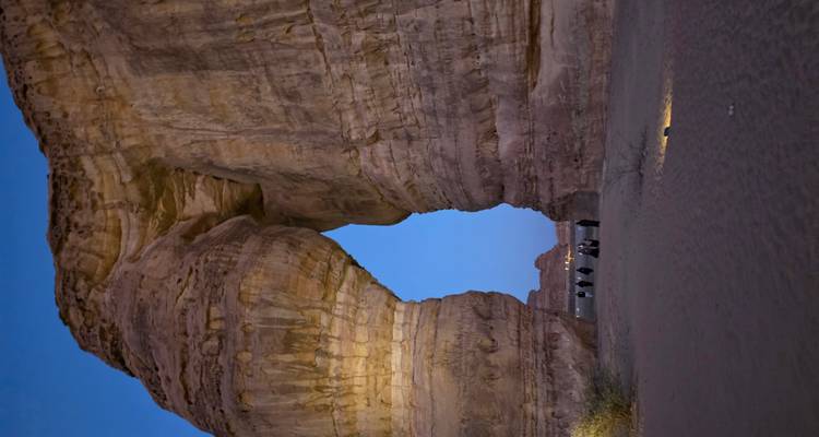 Olifantsrots in een woestijnlandschap met mensen in de buurt.