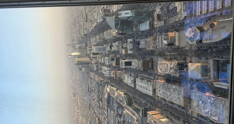 Luchtfoto van een stad met moderne wolkenkrabbers en brede straten.