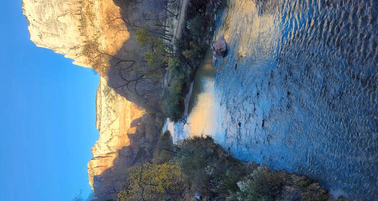 Rivier die door een canyon stroomt onder een heldere blauwe hemel.