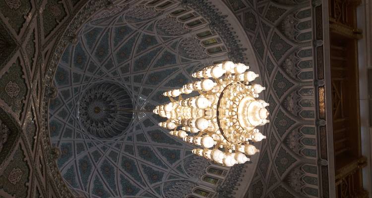 Araña de luces intrincada y techo abovedado en una mezquita.