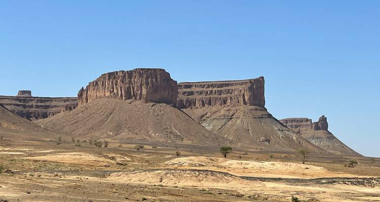 Felsige, trockene Landschaft mit hohen Felsformationen unter einem klaren Himmel.