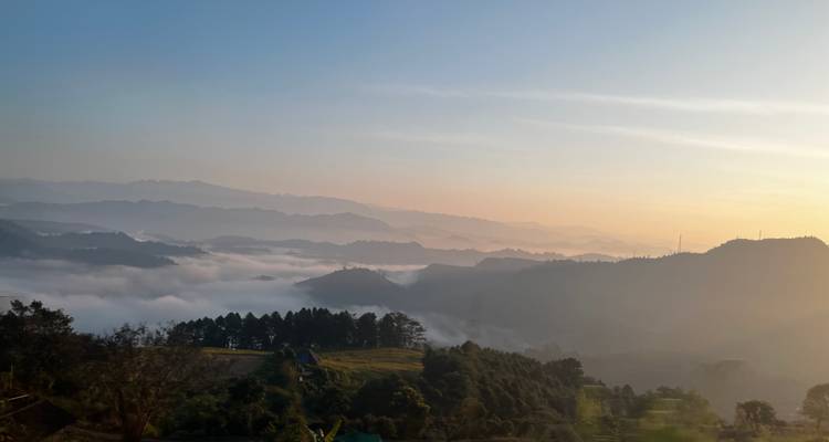 Ein atemberaubender Blick auf neblige Berge bei Tagesanbruch.