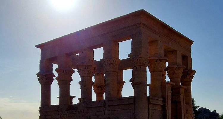 Ruins of an ancient Egyptian temple with columns and sunlight above.