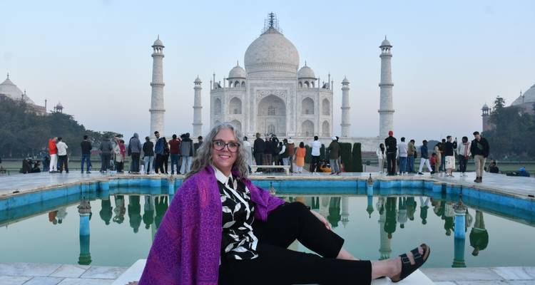 Individuo sentado frente al Taj Mahal con una piscina reflectante.
