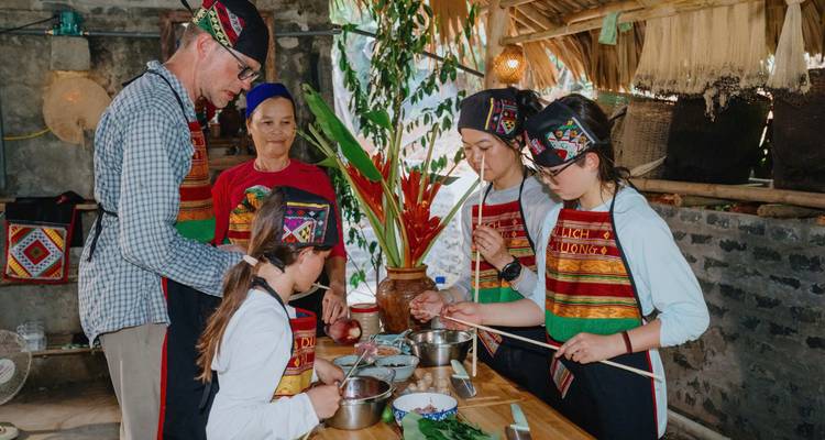 Groupe de personnes préparant de la nourriture dans un cadre traditionnel.