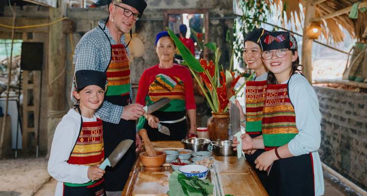 Groupe de personnes souriantes posant avec des ingrédients de cuisine.